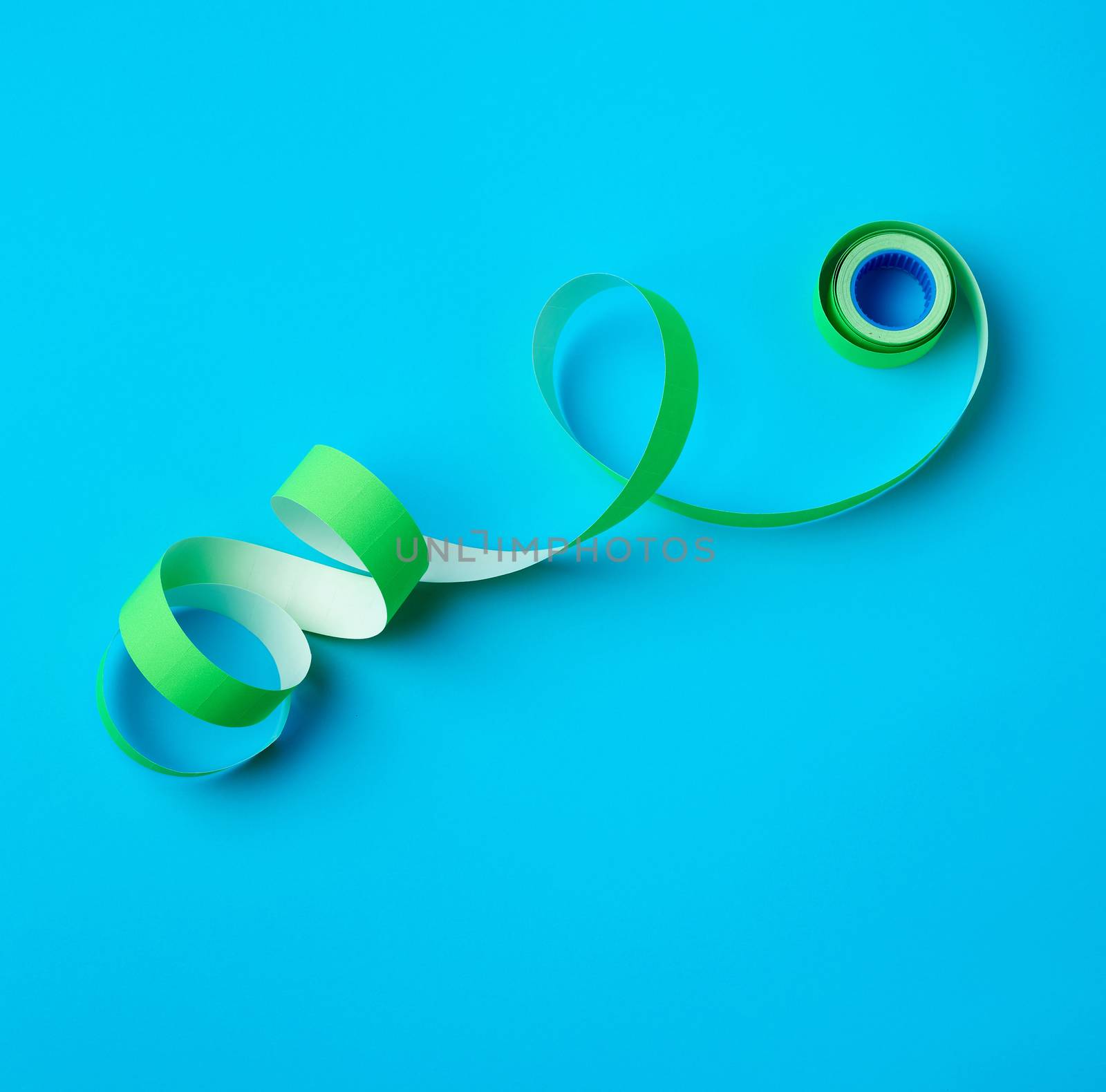 untwisted reel with green sticky stickers on a blue background, top view
