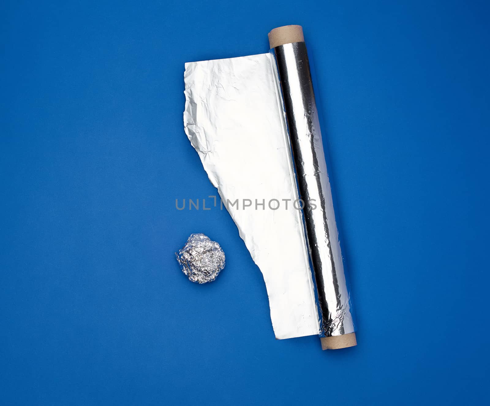 roll of gray foil for baking and packaging food on a dark blue background, torn edge