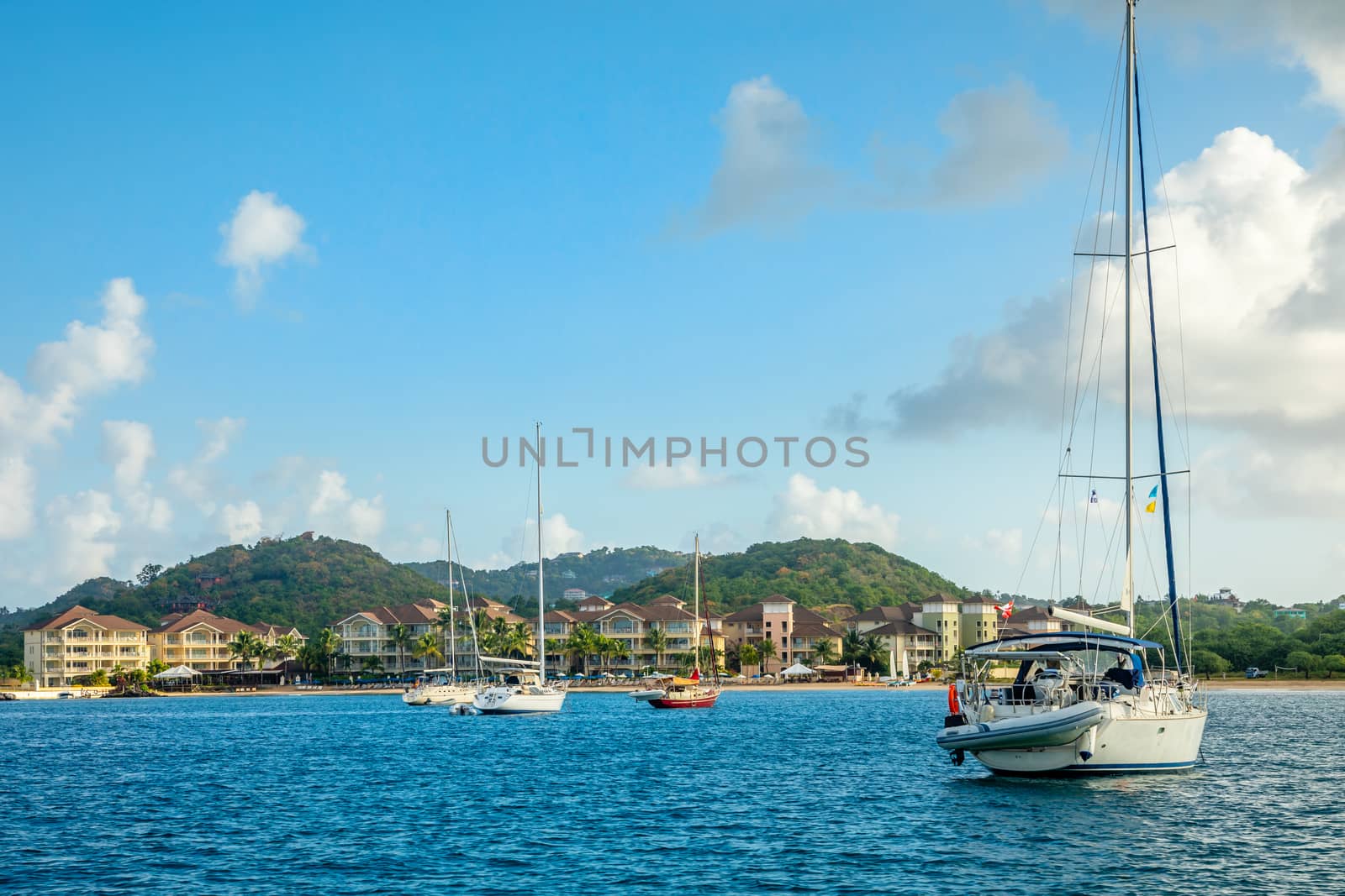 Offshore view of Rodney bay with yachts anchored in the lagoon and rich resorts in the background, Saint Lucia, Caribbean sea