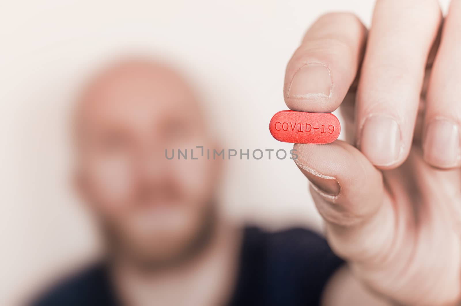 Illustration of a cure for Coronavirus Covid-19, man holding a pill with Covid-19 label.