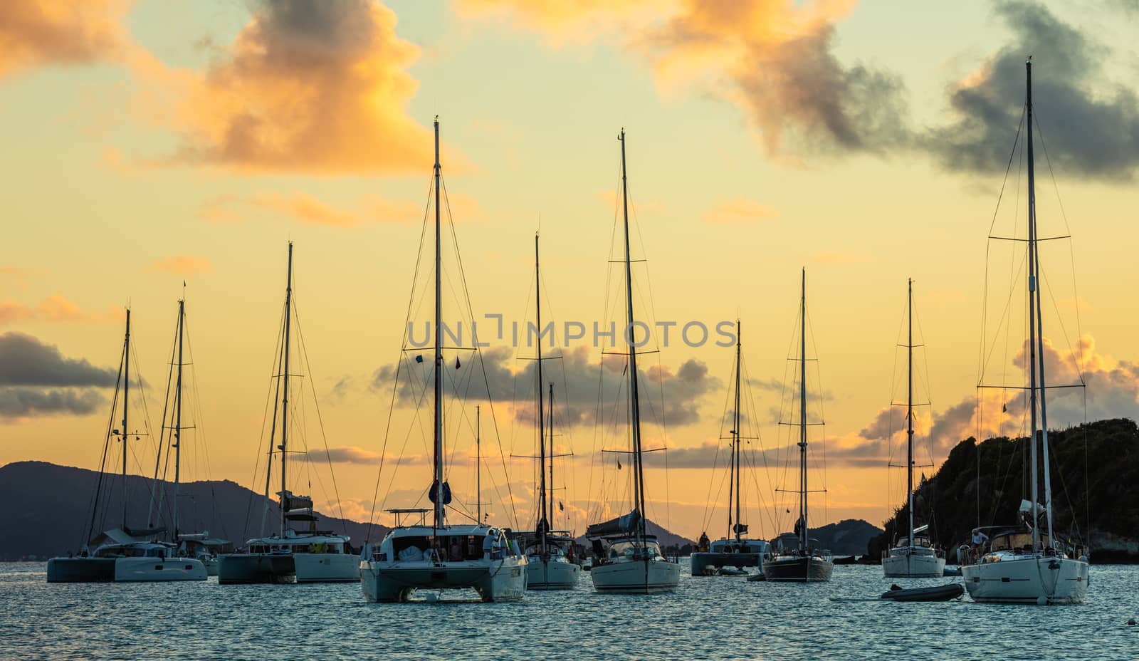 Sunset panorama with lots of parked yachts and catamarans, Tobag by ambeon