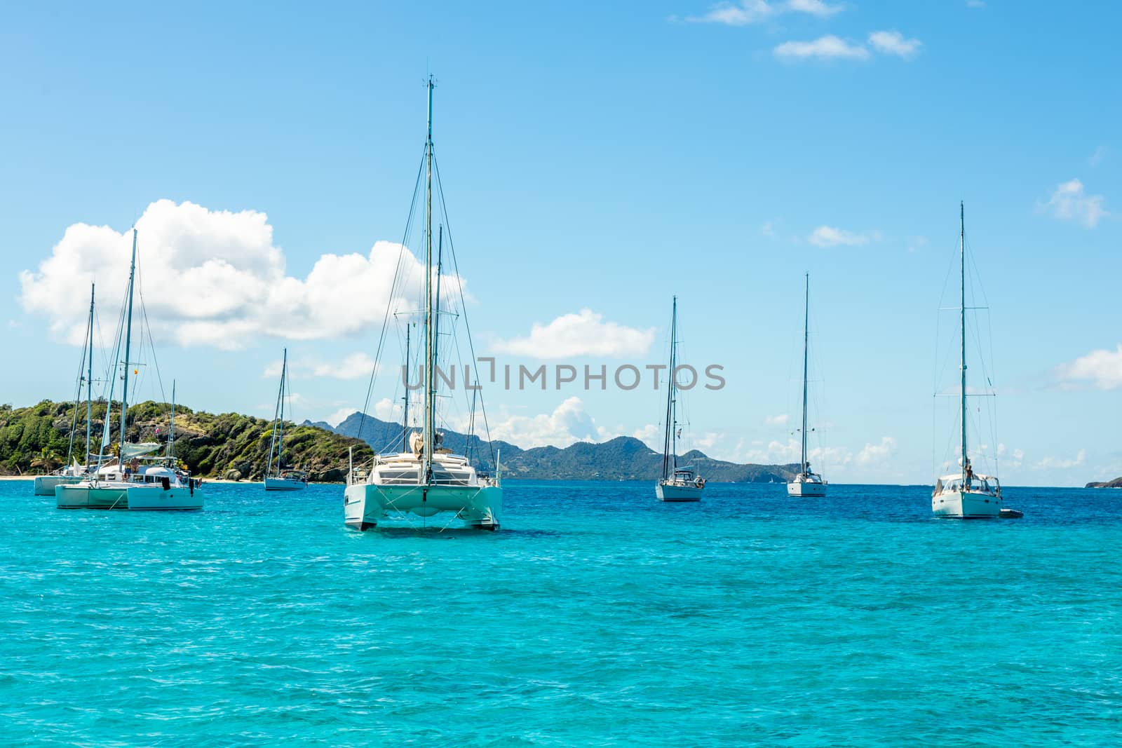 Turquoise colored sea with ancored yachts and catamarans, Tobago by ambeon