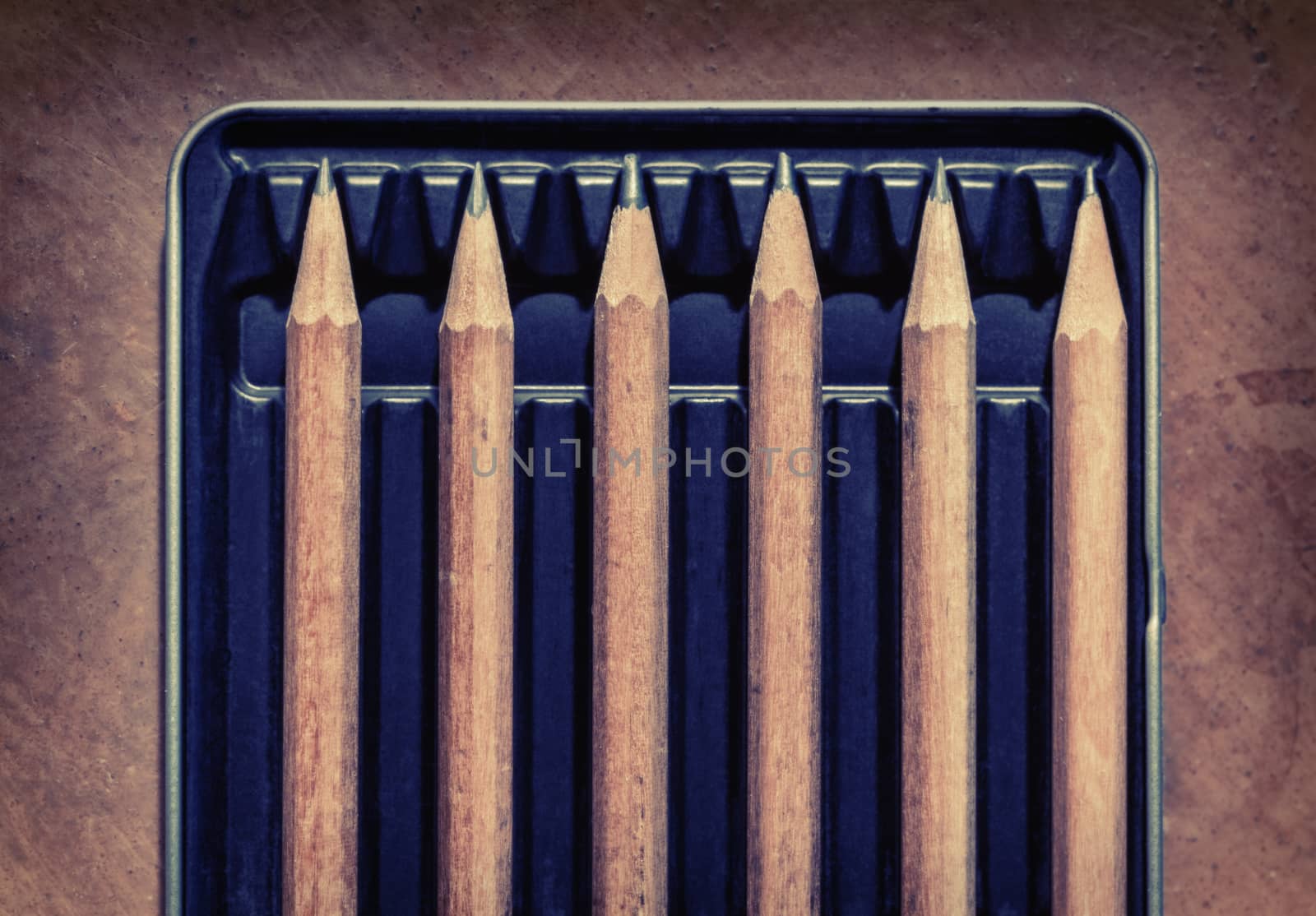 Wooden pencils in a box, separated by an empty space. Concept picture for social distancing.