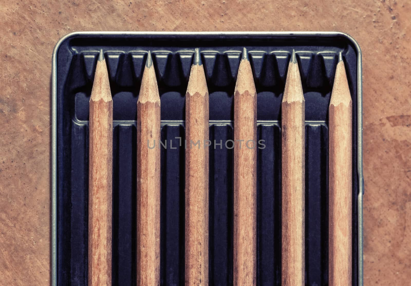 Wooden pencils in a box, separated by an empty space. Concept picture for social distancing.