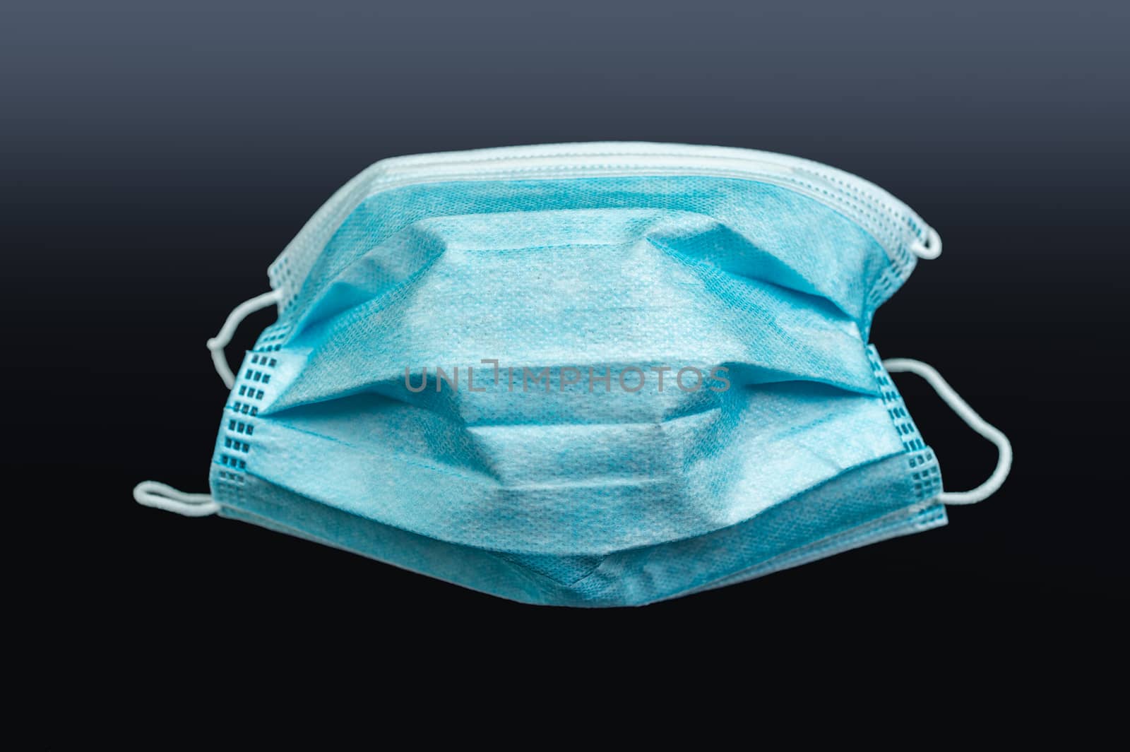 covid-19 surgical mask over dark background