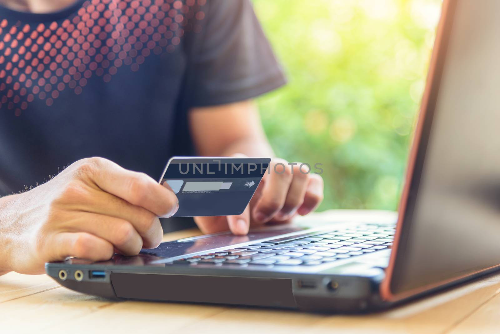 the man wear mask and holding the credit card for shopping online in website by rukawajung