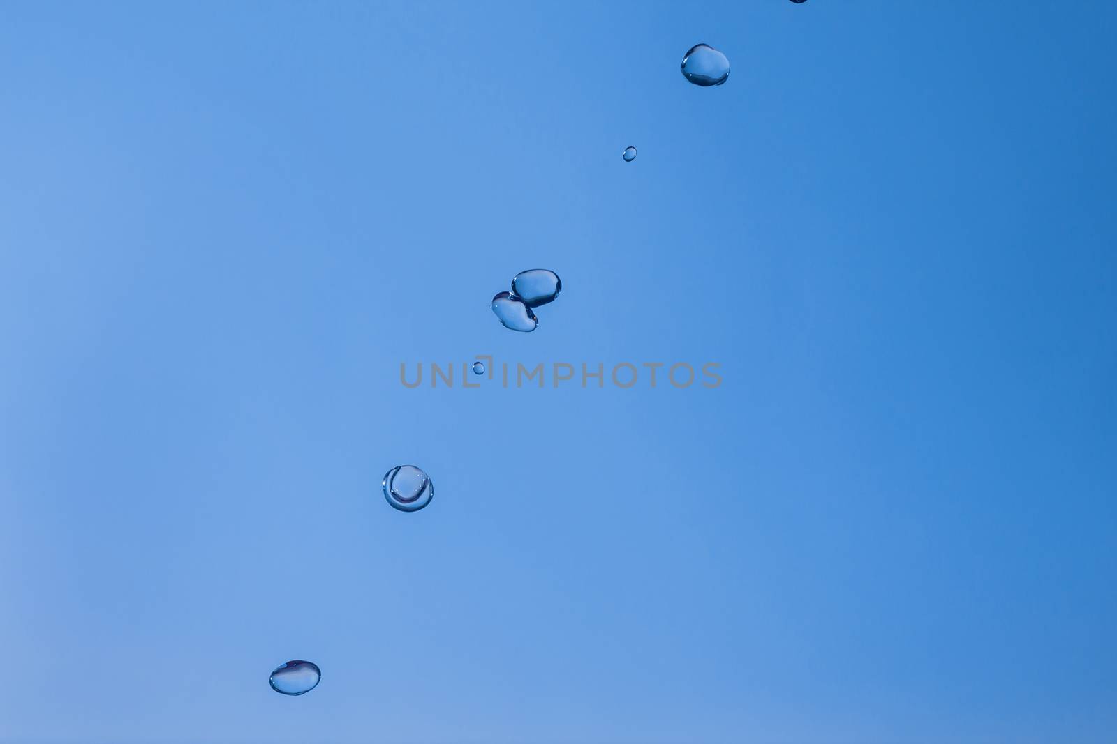 Water bubbles in the blue sky. Water drops on blue background. Aqua, rain, weather, clear. Life, freedom, ease.