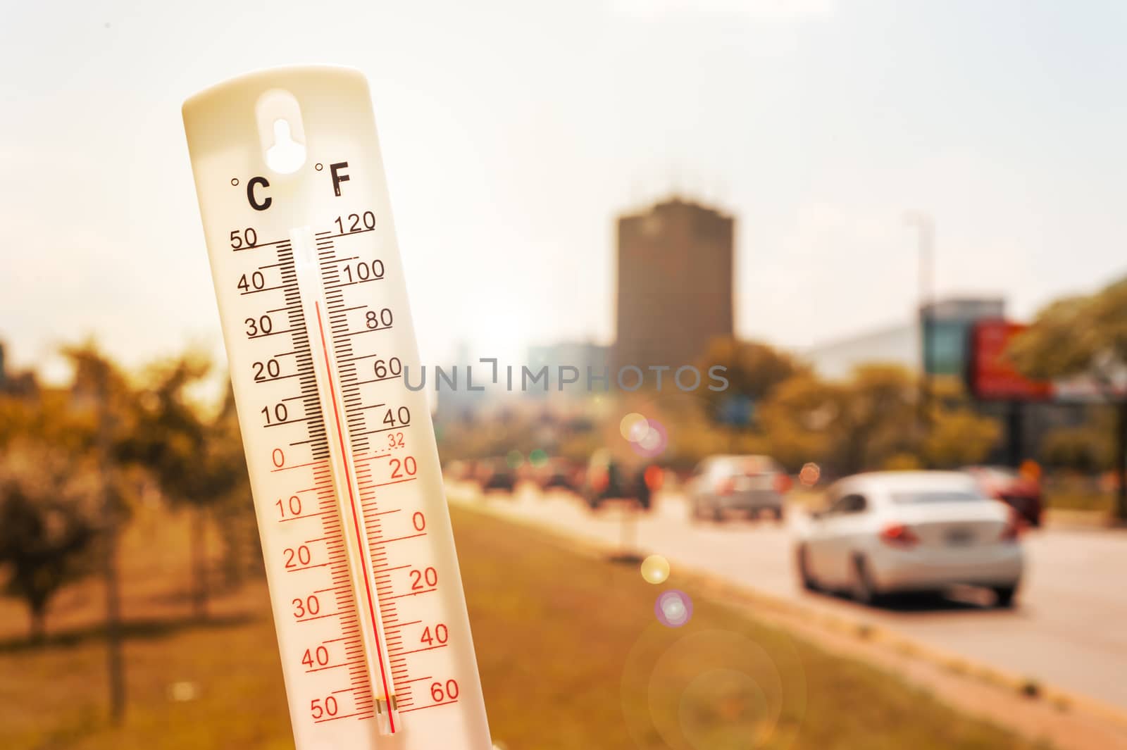 Thermometer in front of cars and traffic during heatwave by mbruxelle