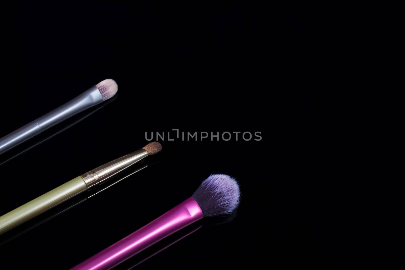 Makeup brushes on black background. Cosmetics, fashion, beauty, glamour. Accessories for make-up artist.