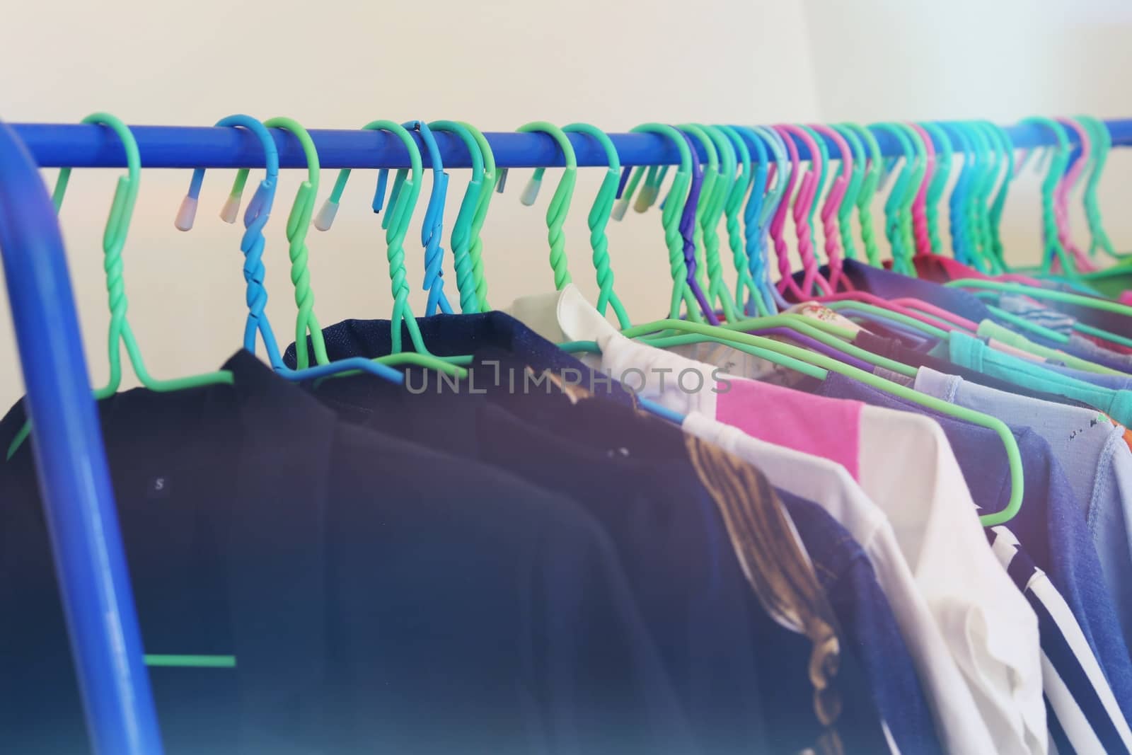 Selective focus of clothes hanging on rack with light effect