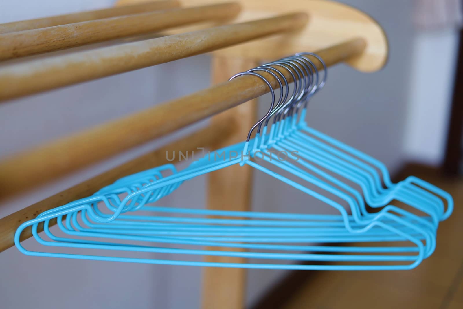 Empty clothes hangers on wooden rack by iamnoonmai