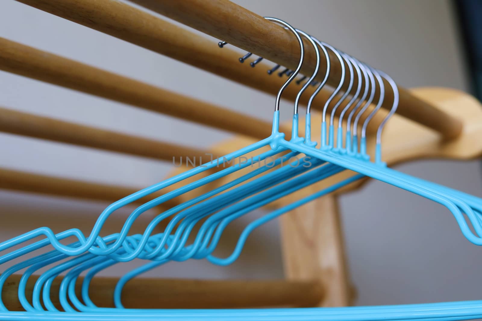 Empty clothes hangers on wooden rack by iamnoonmai