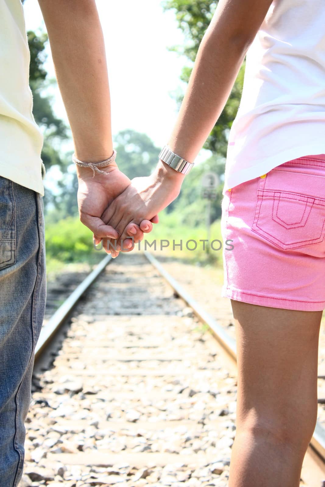 Loving couple holding hands and walking together by iamnoonmai