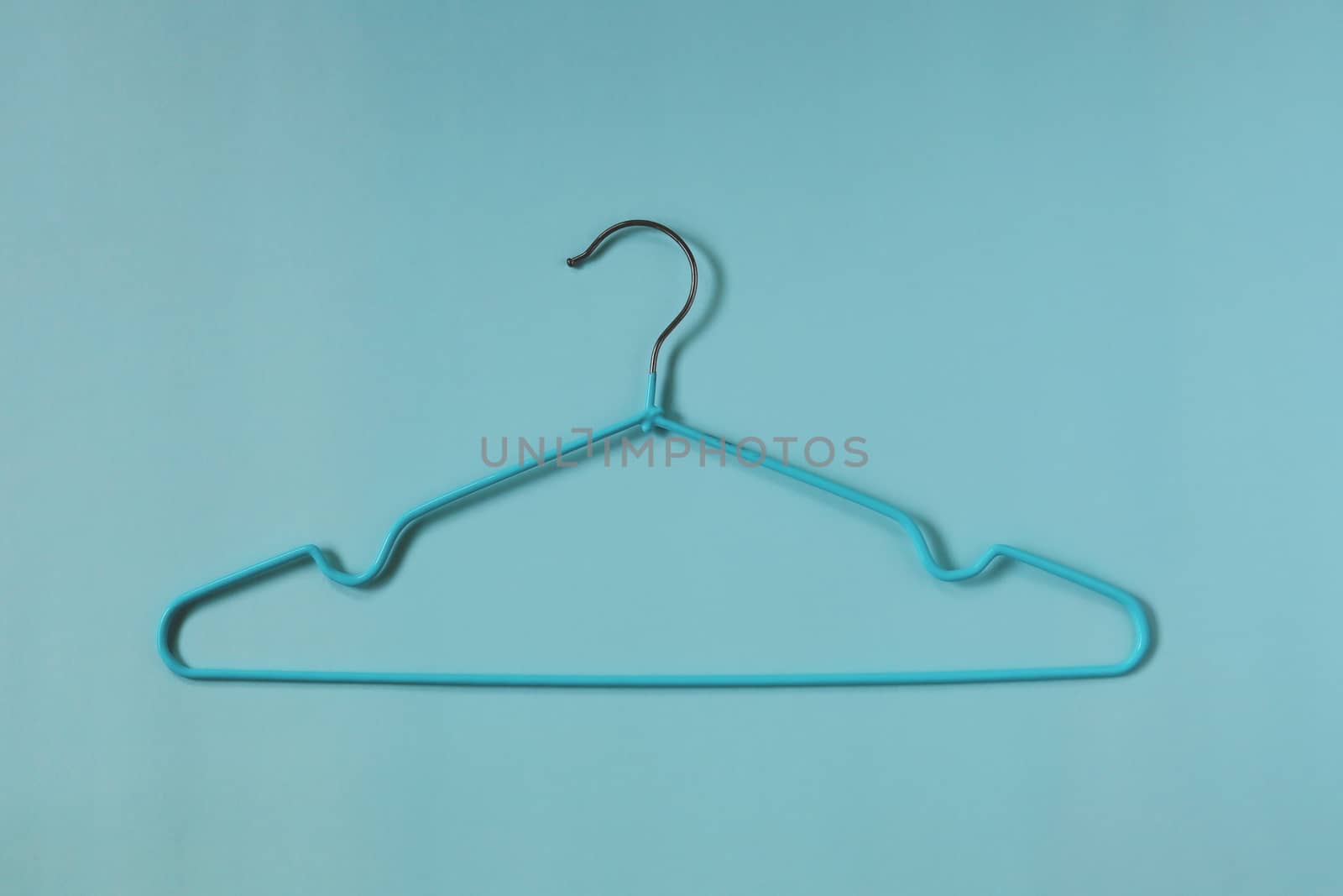 Clothes hangers on blue background for household items.