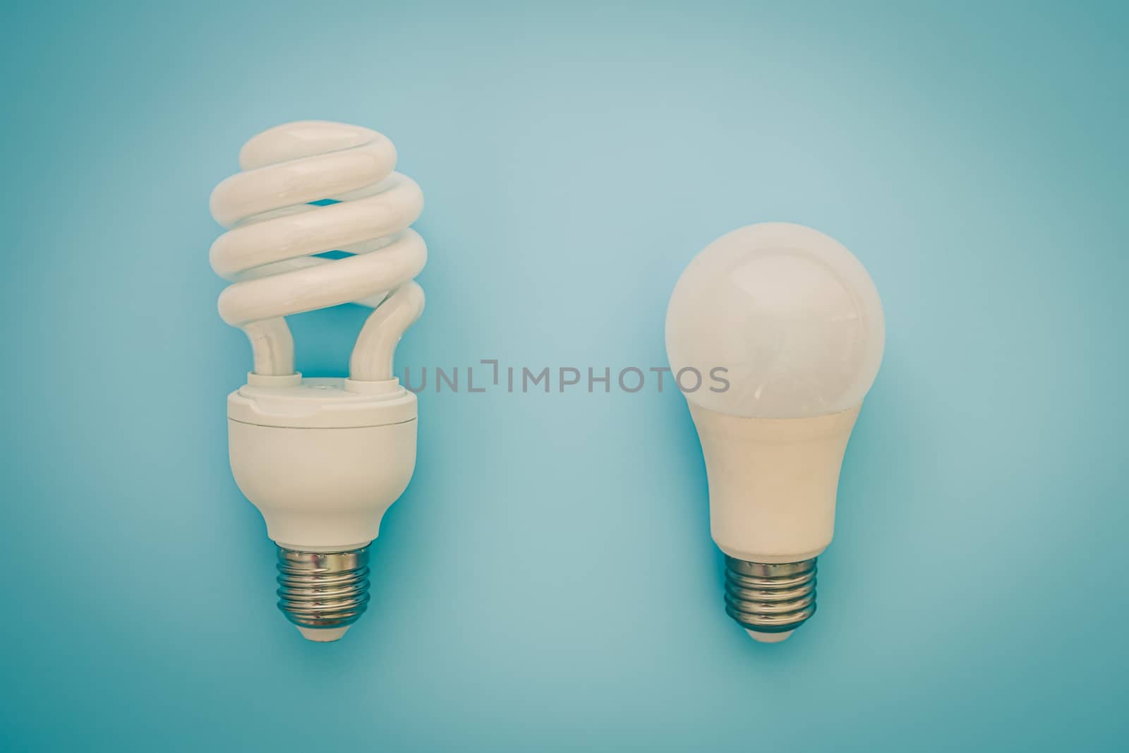 Fluorescent and LED light bulb on blue background for energy savings concept