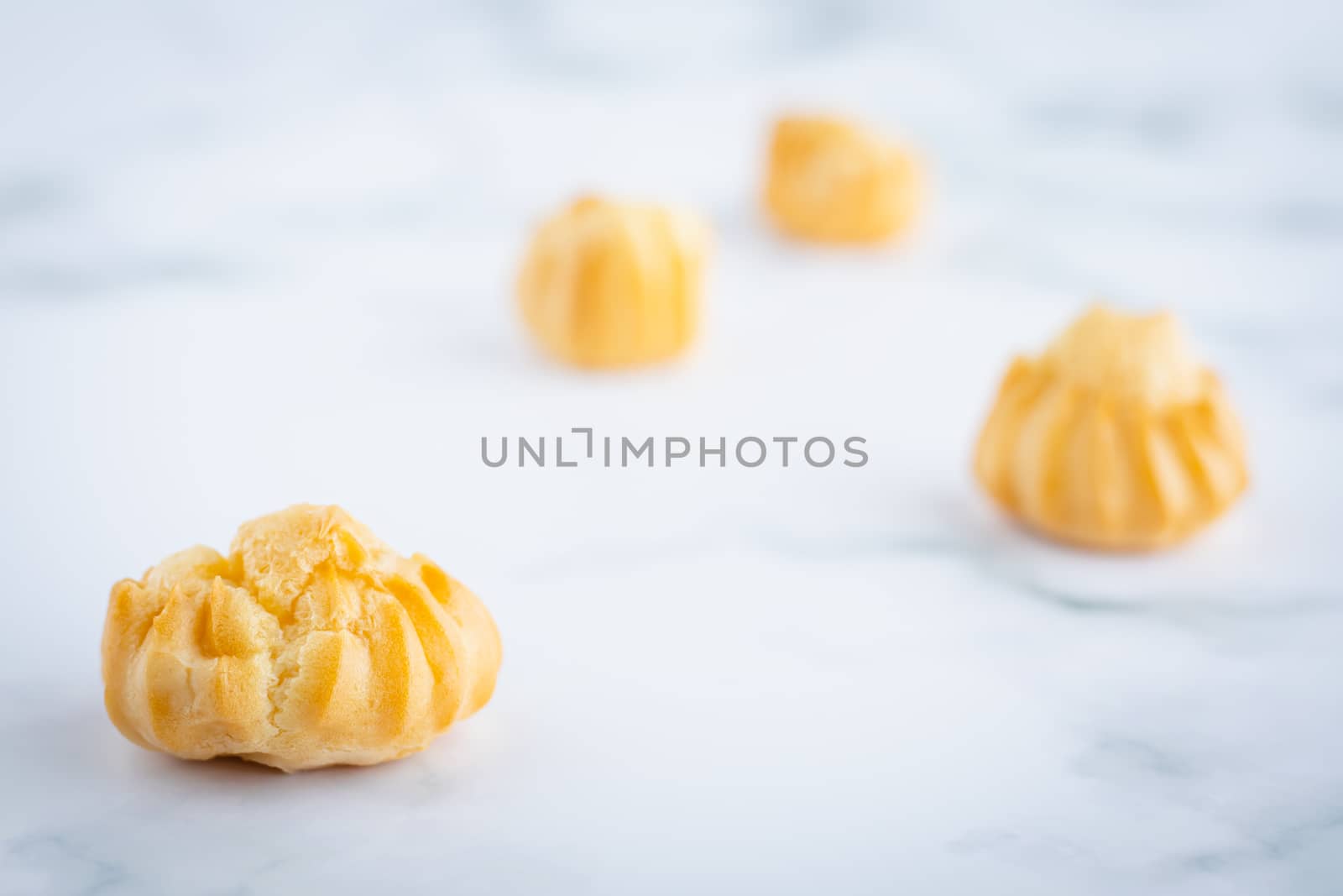 Delicious eclair vanilla cream, choux dough filled with a cream, homemade bakery on white marble background for snack eating concept