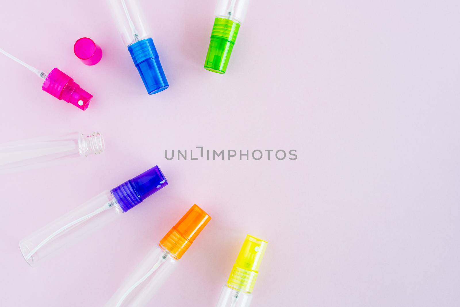 Transparent glass perfume and cosmetic spray bottle on pink background for product packaging concept