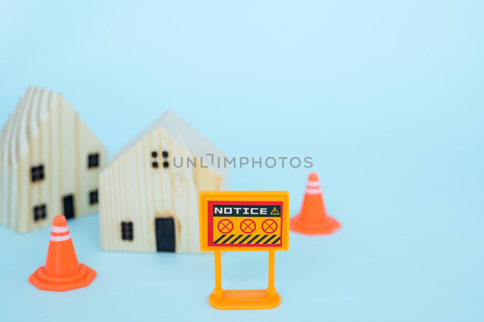 Prohibition sign with blurred wooden house model on blue background for self-quarantine and staying home in coronavirus or Covid-2019 situation concept