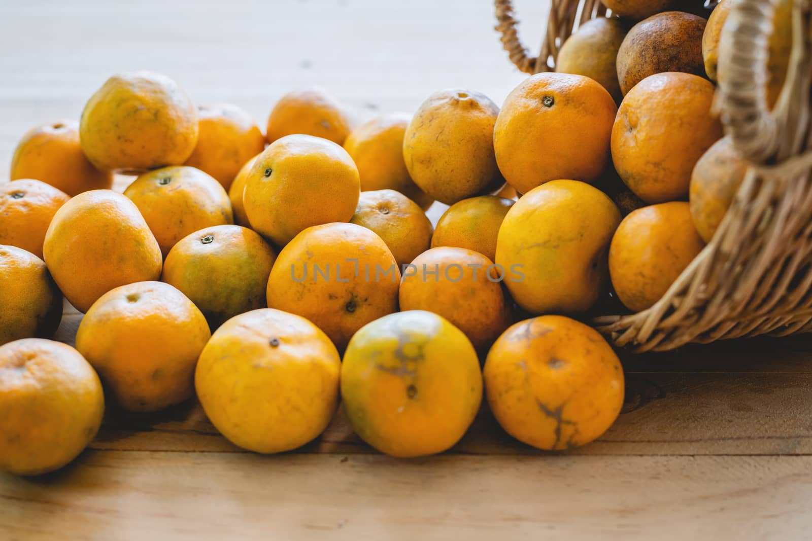 Orange in the wicker basket on wooden table for fruit and eating concept