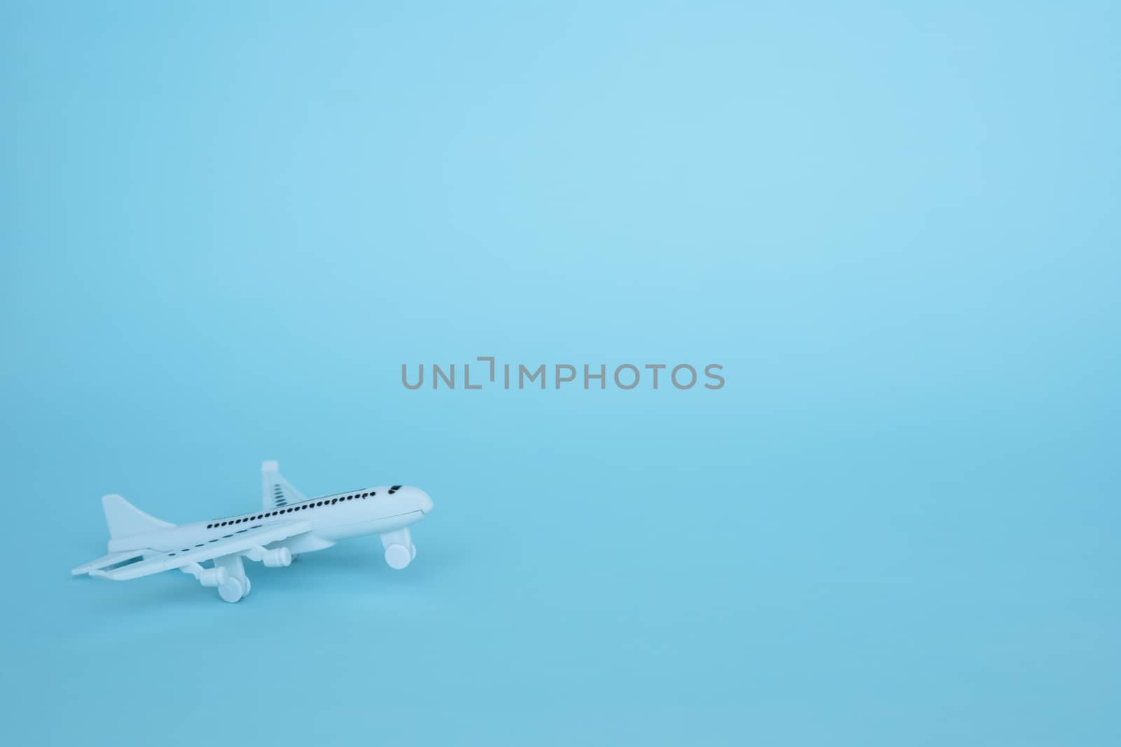 White airplane model on blue background for vehicle and transportation concept