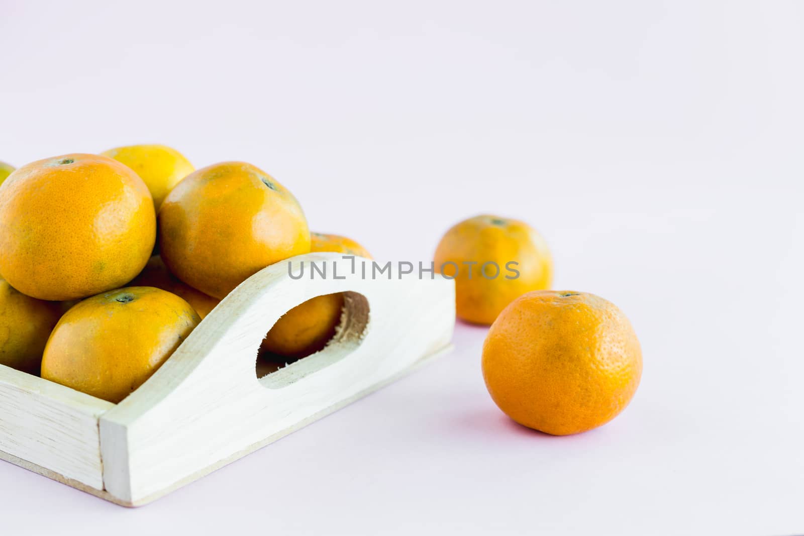 Orange in the wooden box on pink background for fruit and eating concept