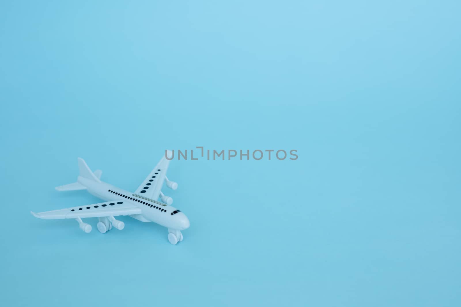 White airplane model on blue background for vehicle and transportation concept