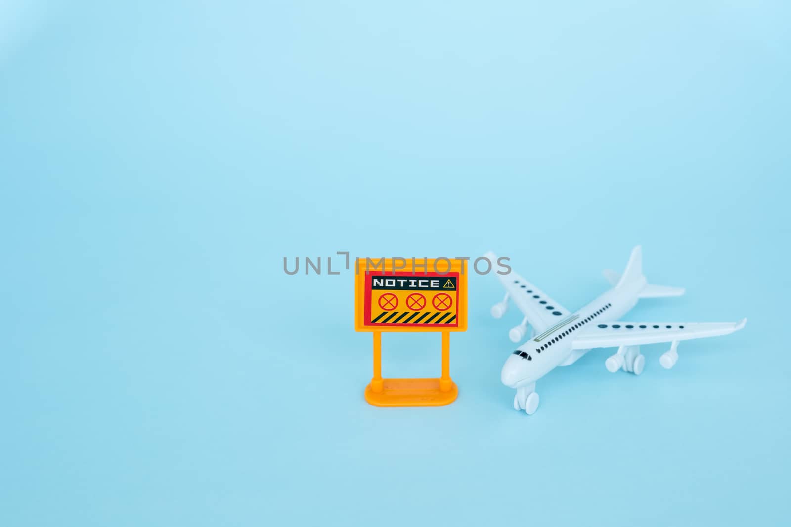 White airplane model with prohibition sign on blue background for vehicle and transportation in coronavirus or Covid-2019 situation concept