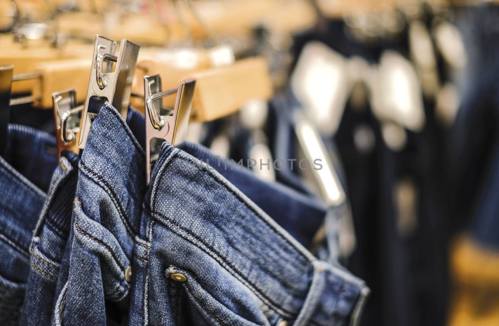 Row of hanged blue jeans pants in shop