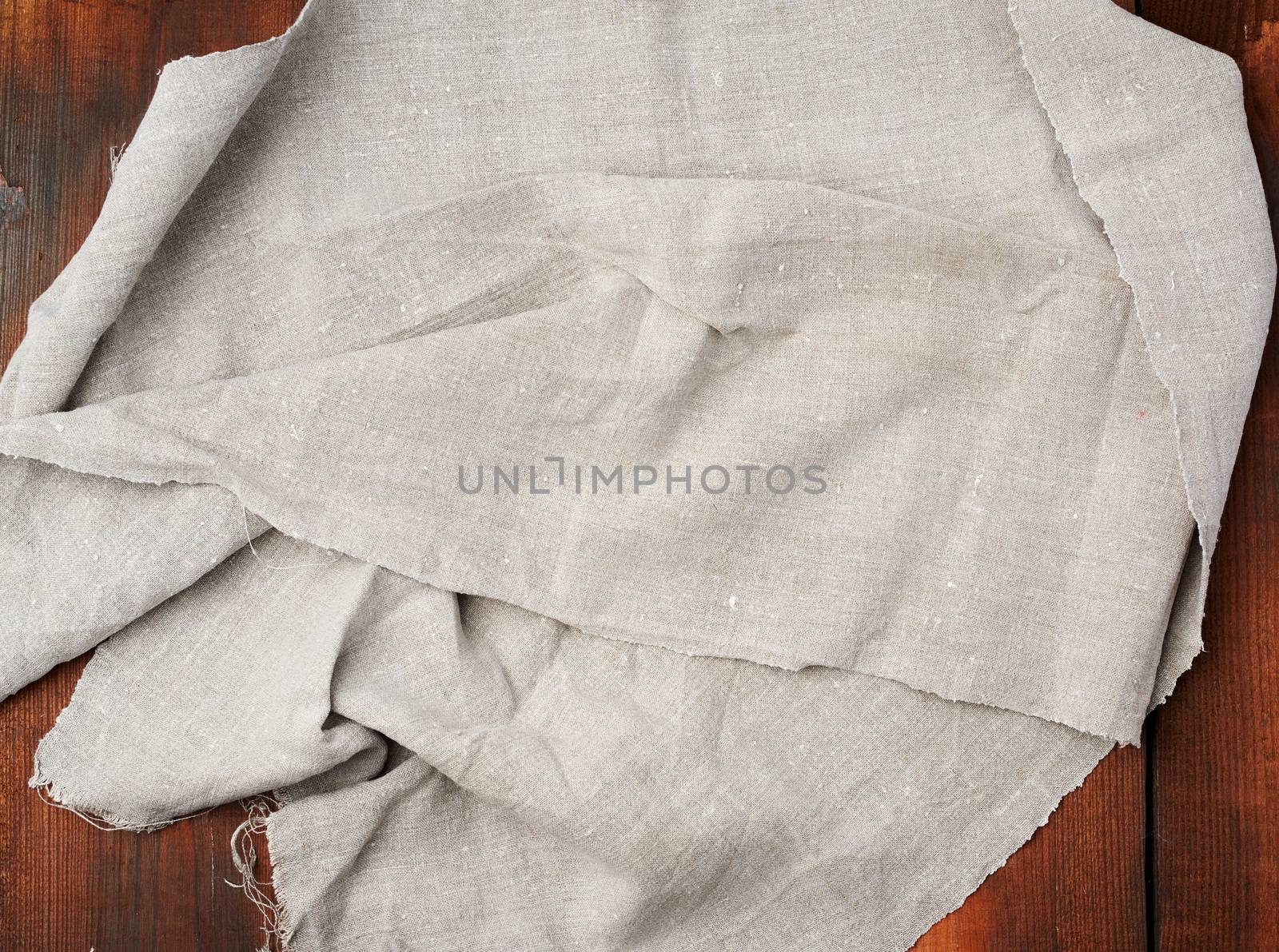 folded gray linen towel on wooden background, top view, copy space