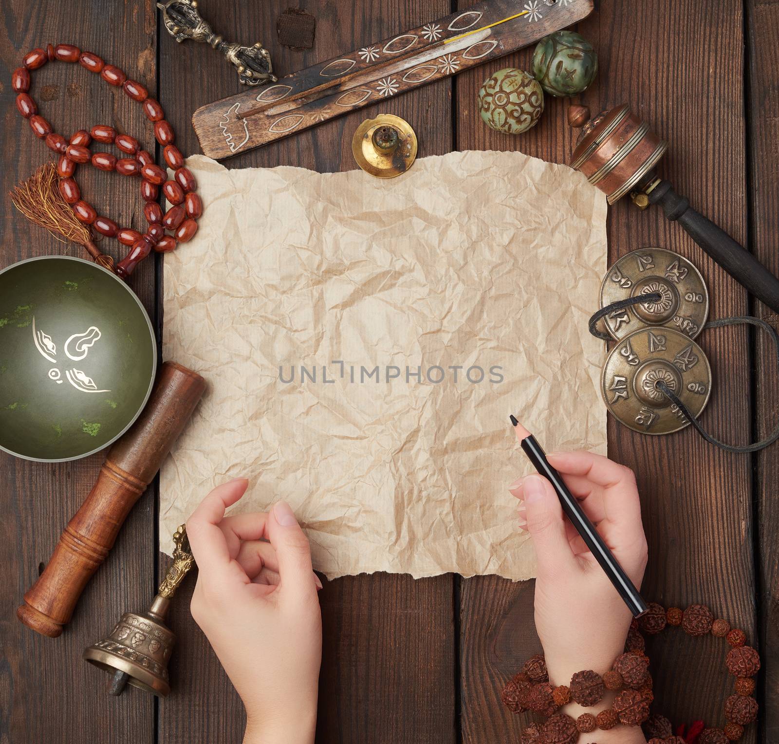 tibetan religious objects for meditation and alternative medicine, empty brown sheet of paper on a brown  wooden background, top view, copy space