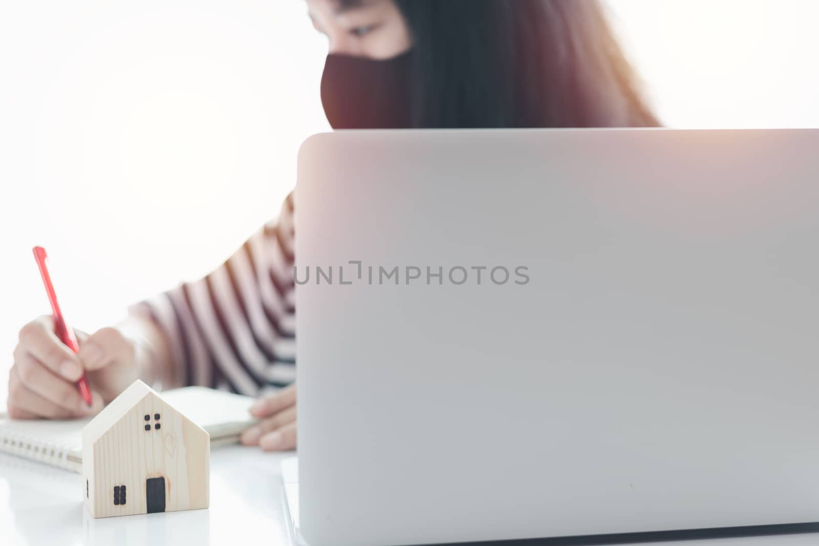 Woman using laptop and working at home for business, self-quarantine, staying home and social distancing in coronavirus or Covid-2019 outbreak situation concept