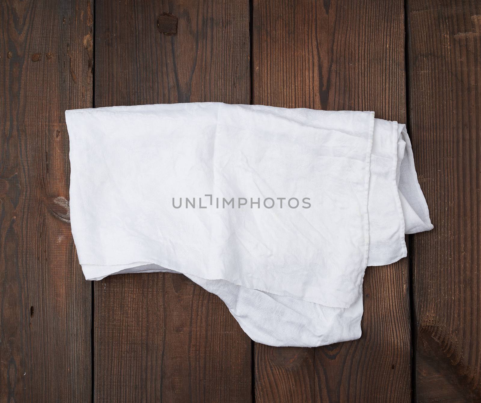 white linen towel on wooden background, top view, copy space