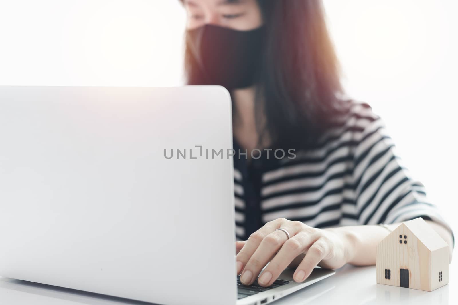 Woman using laptop and working at home for business, self-quarantine, staying home and social distancing in coronavirus or Covid-2019 outbreak situation concept