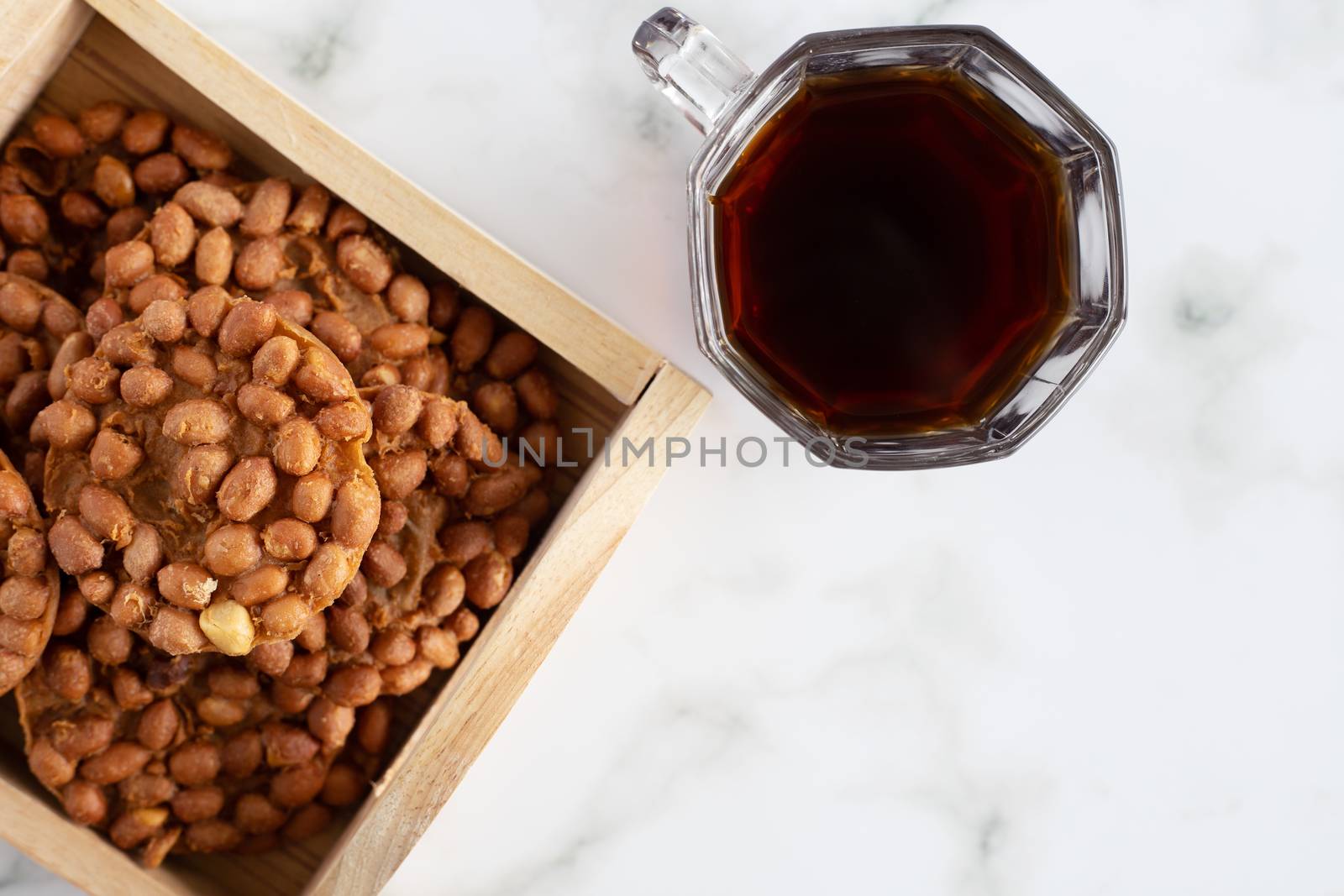 Thai fried peanut cookies with a cup of tea for asian dessert, food and eating concept