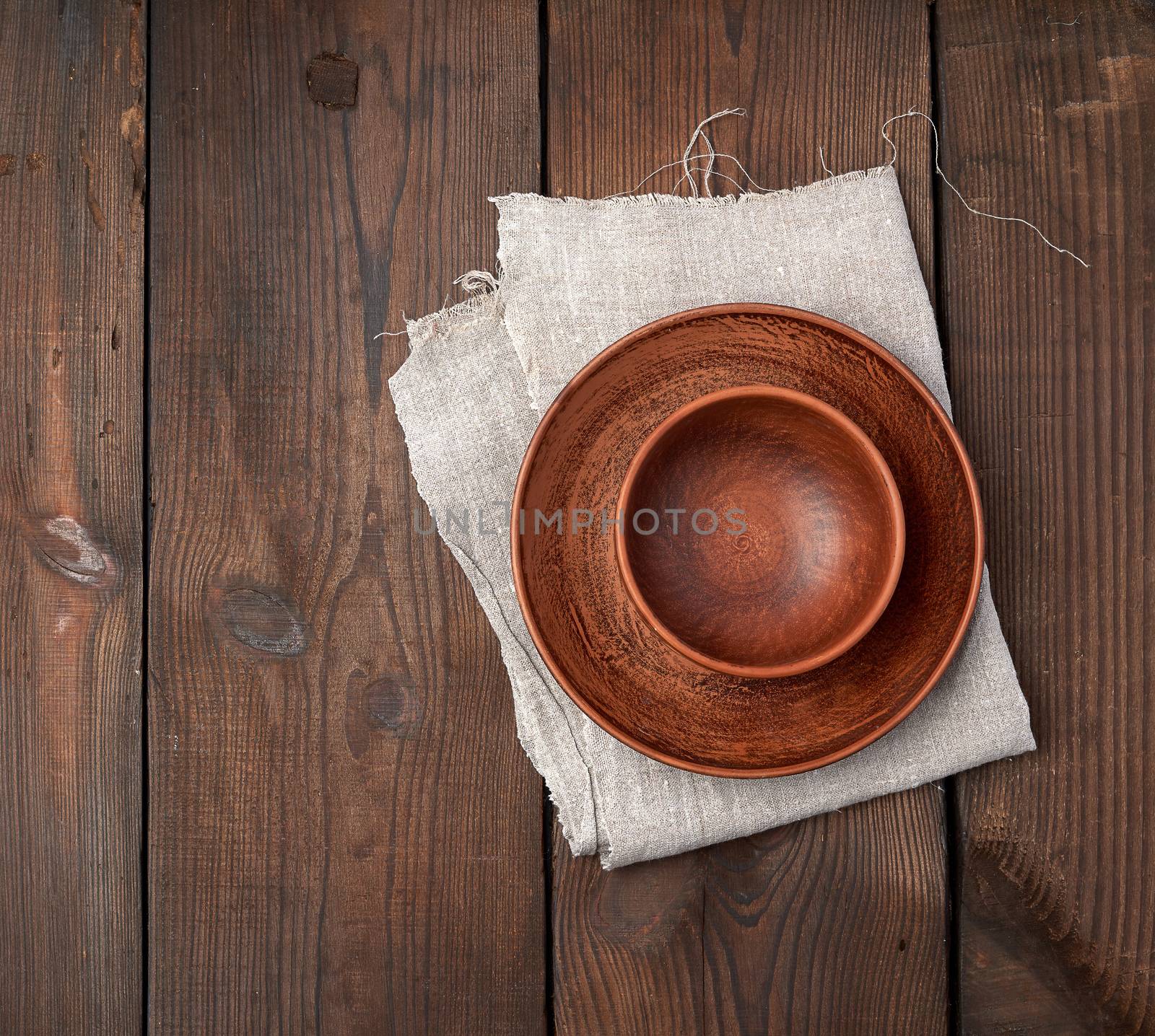 empty brown ceramic plates on a wooden table, top view