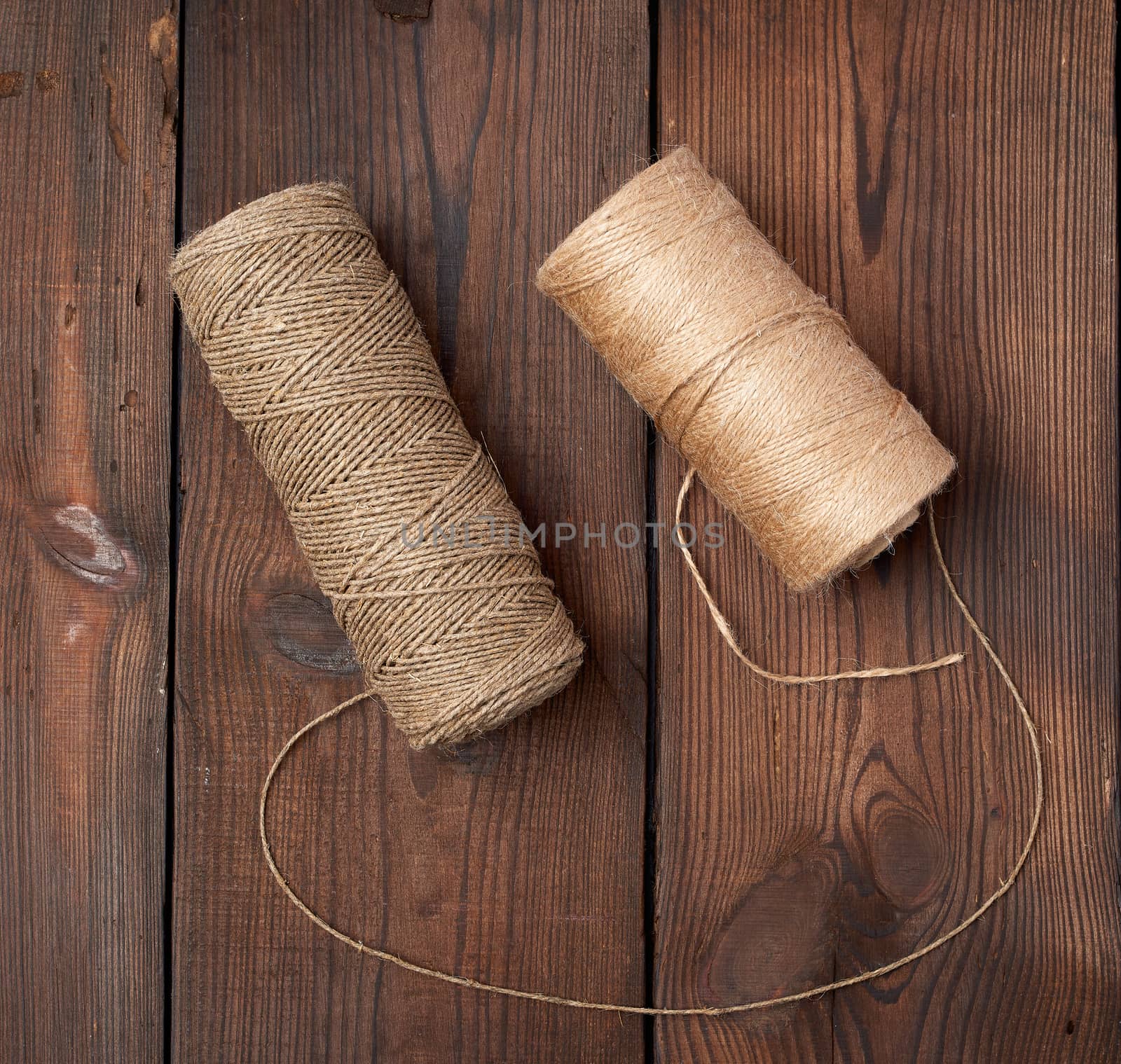 brown thread twisted into a spool on a wooden background, eco products