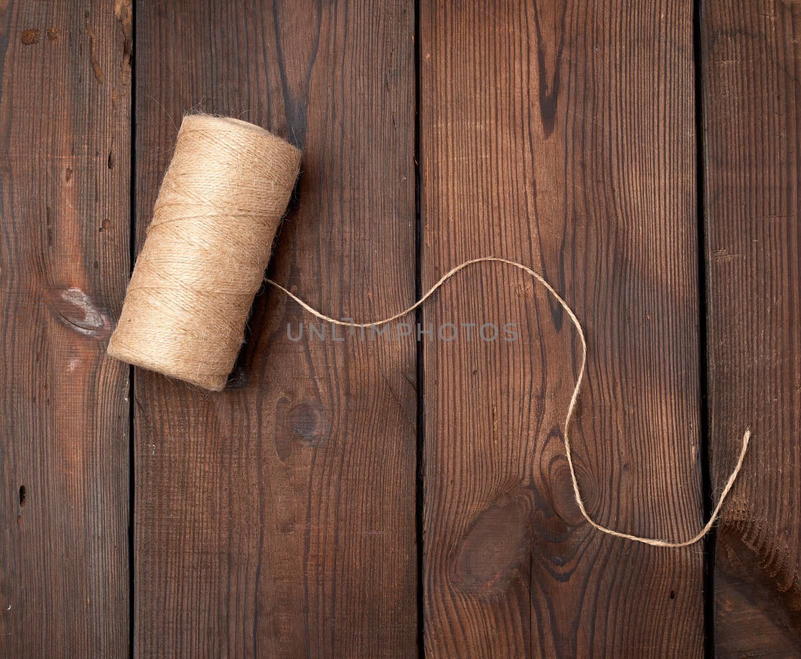 brown thread twisted into a spool on a wooden background, eco products