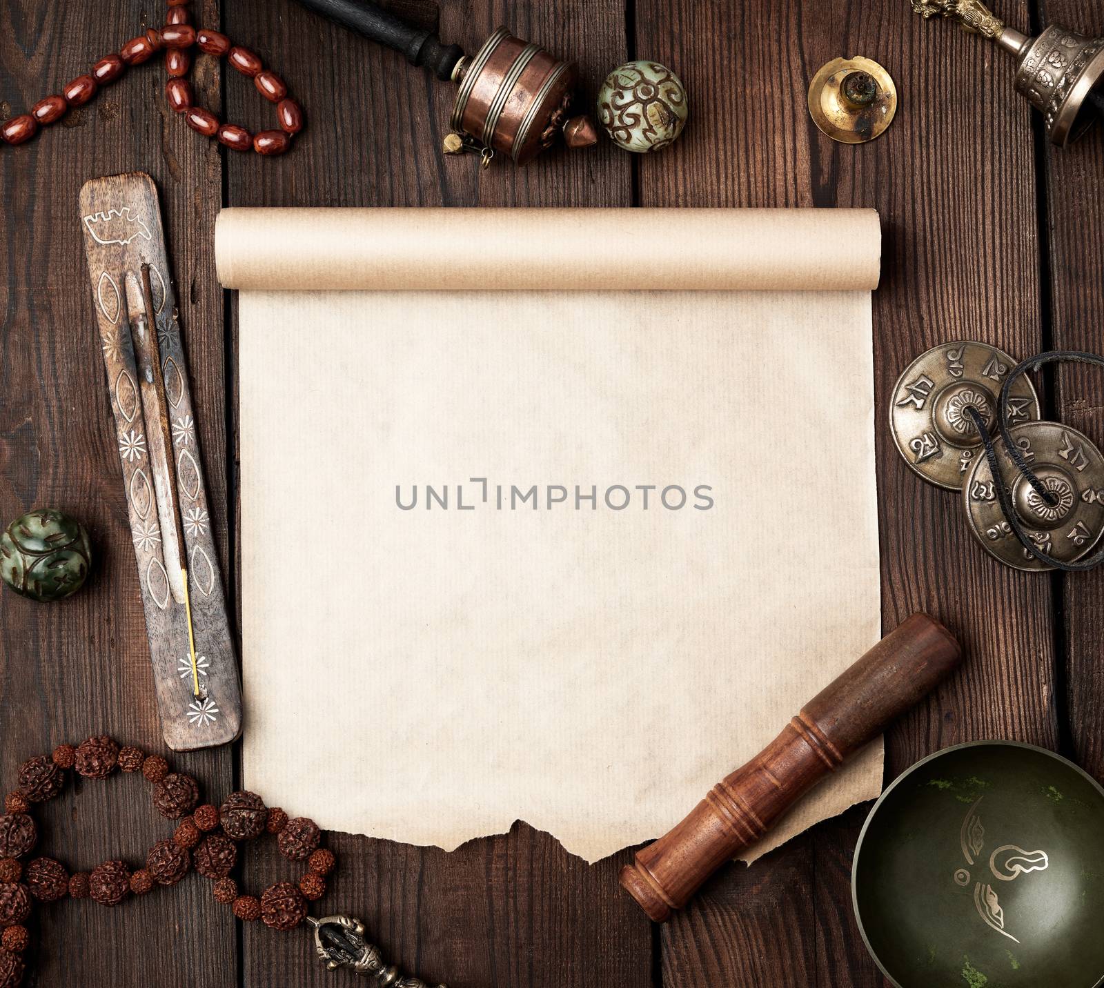 tibetan religious objects for meditation and alternative medicine, empty brown sheet of paper on a brown  wooden background, top view, copy space