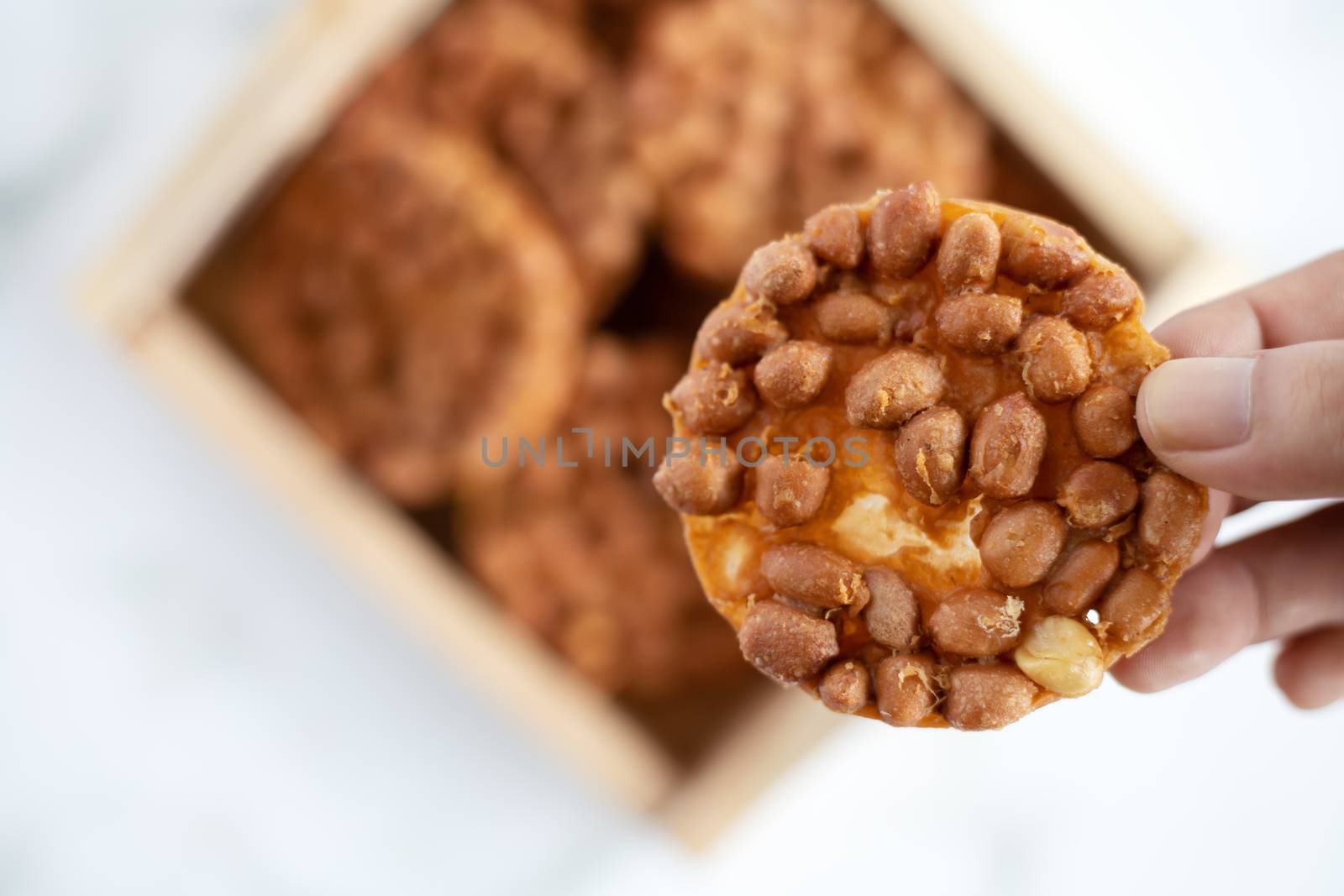 Hand holding Thai fried peanut cookies for asian dessert, food and eating concept