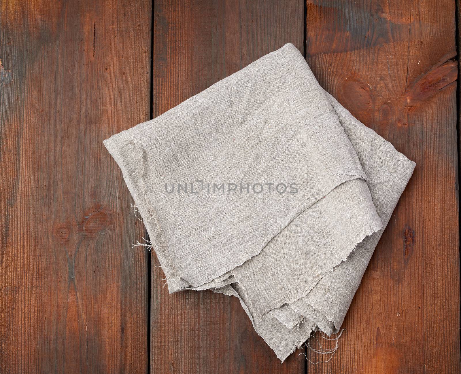 folded gray linen towel on wooden background, top view, copy space