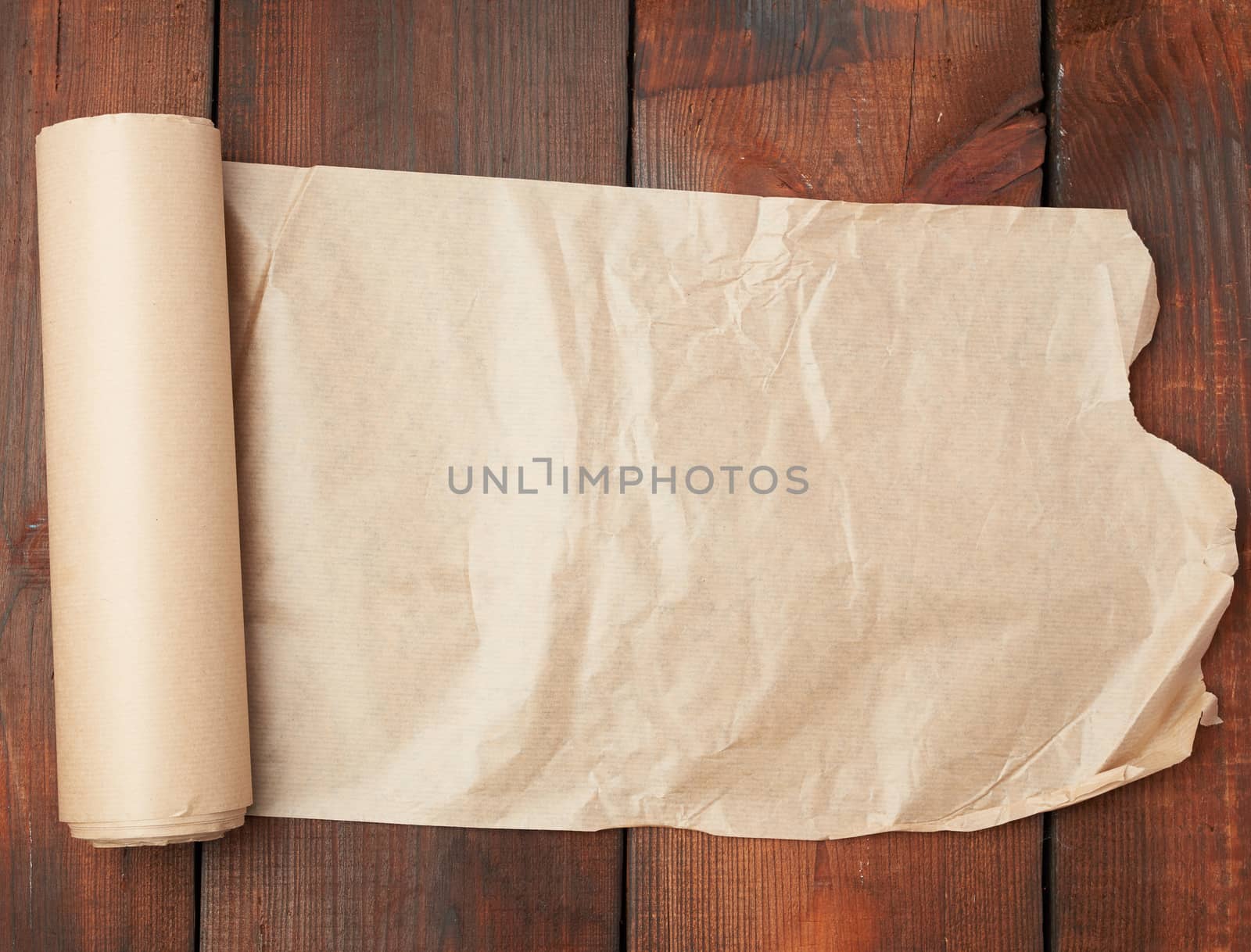 roll of untwisted brown paper on a wooden surface from old boards, copy space