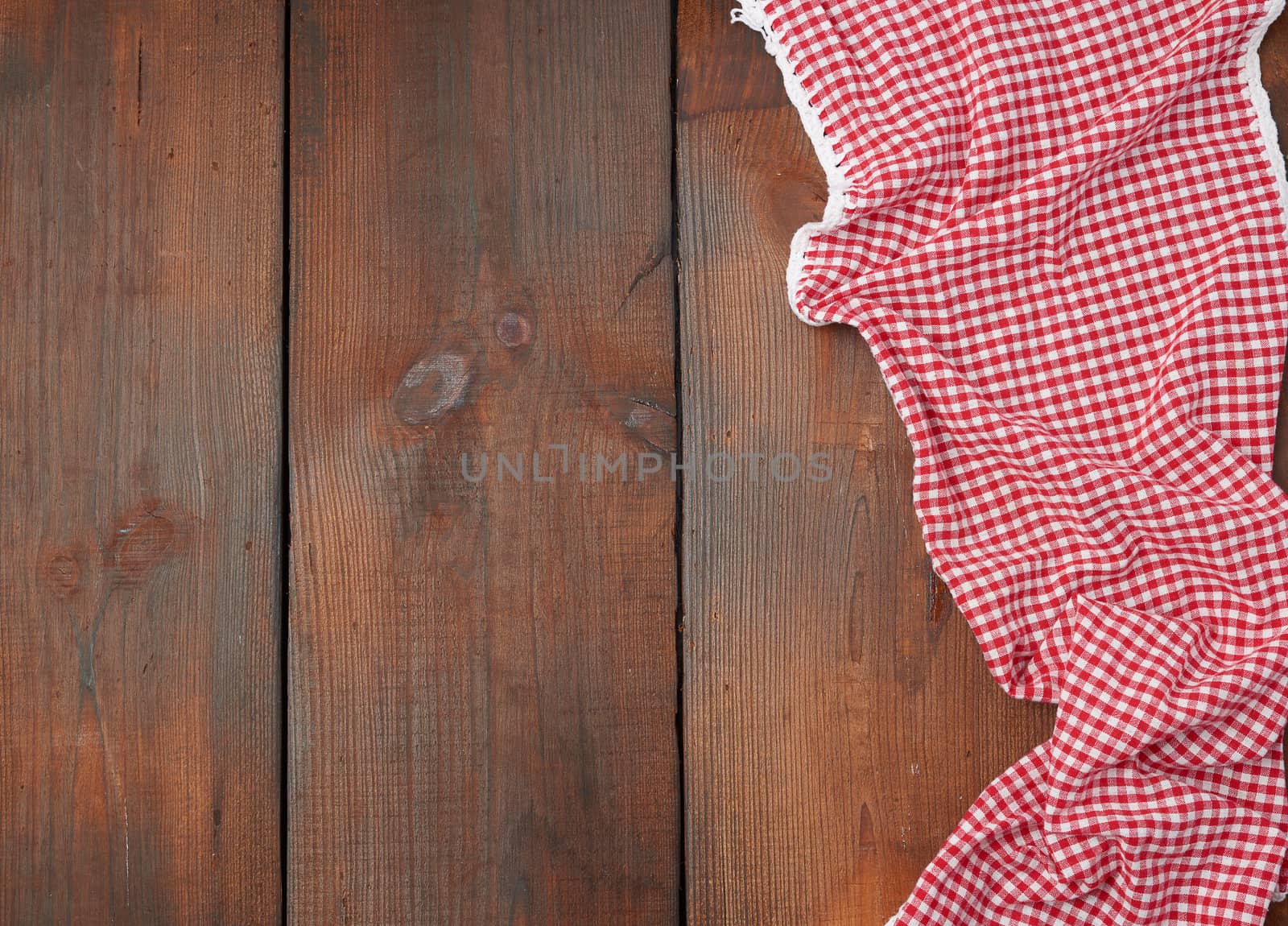 white red checkered kitchen towel on a brown wooden background, picnic background, copy space