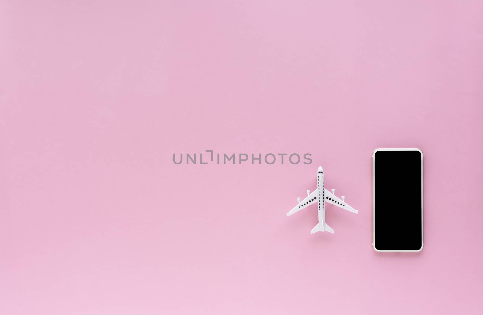 Blank screen of smartphone with white airplane model on pink background with copy space for contact, booking flight ticket and travel concept