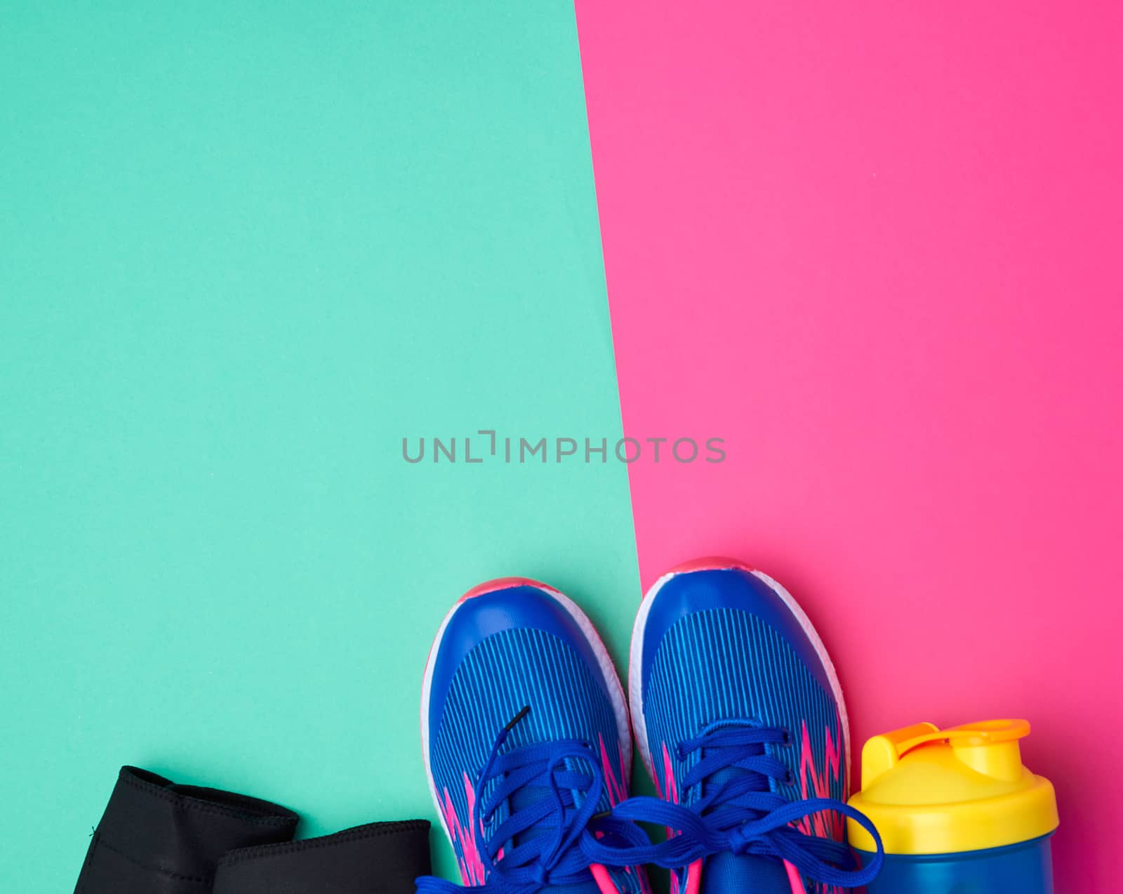 pair of sports sneakers with blue laces on a colored abstract background, top view, place for test