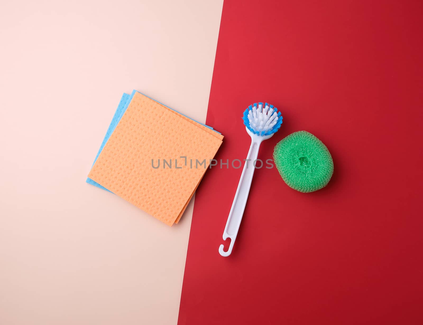 items for home cleaning: brush, multi-colored sponges for dusting on a colored background, top view, flat lay