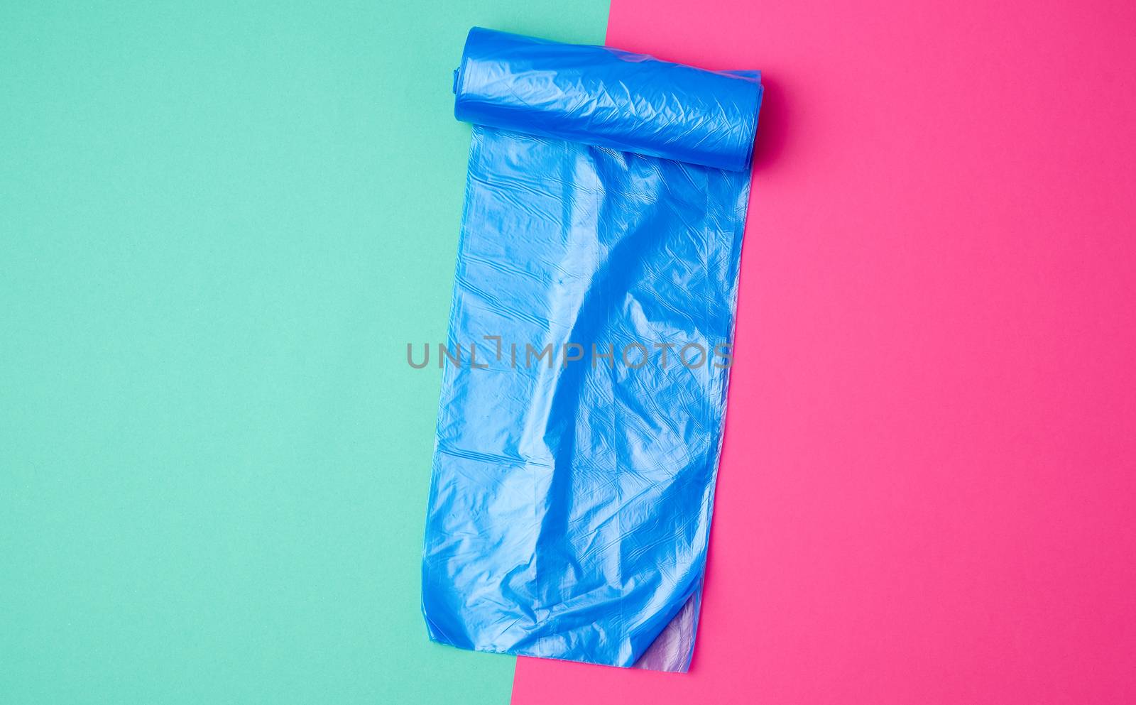 detailed blue plastic bag for collecting garbage and bin on a colored background, top view