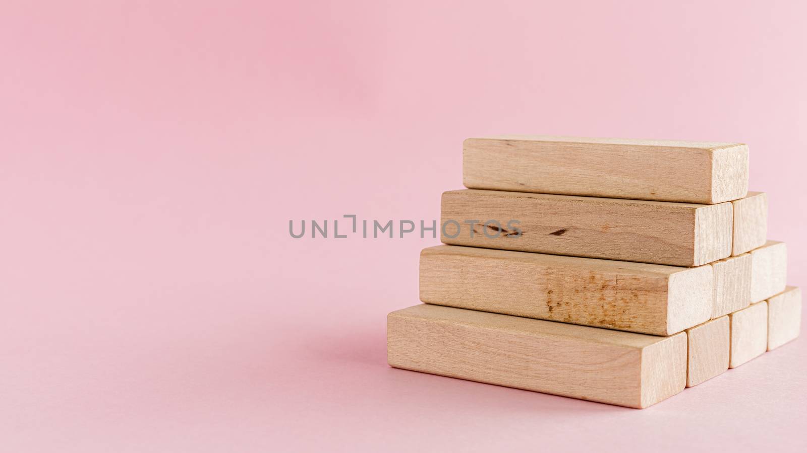 Wooden toy staircase on pink background for step to goal success concept