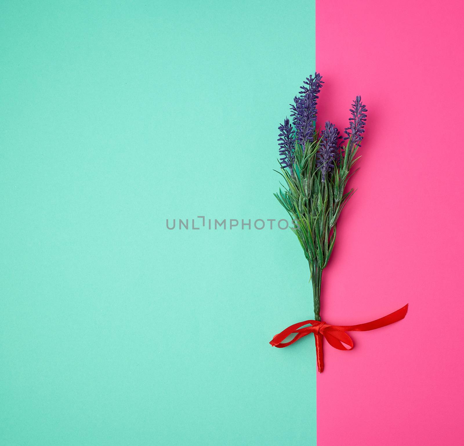 lavender bouquet and red ribbon on a color background, top view, copy space