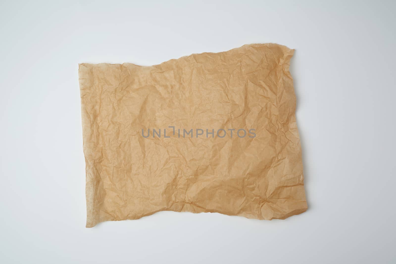 torn brown pieces of parchment paper on a white background, flat lay