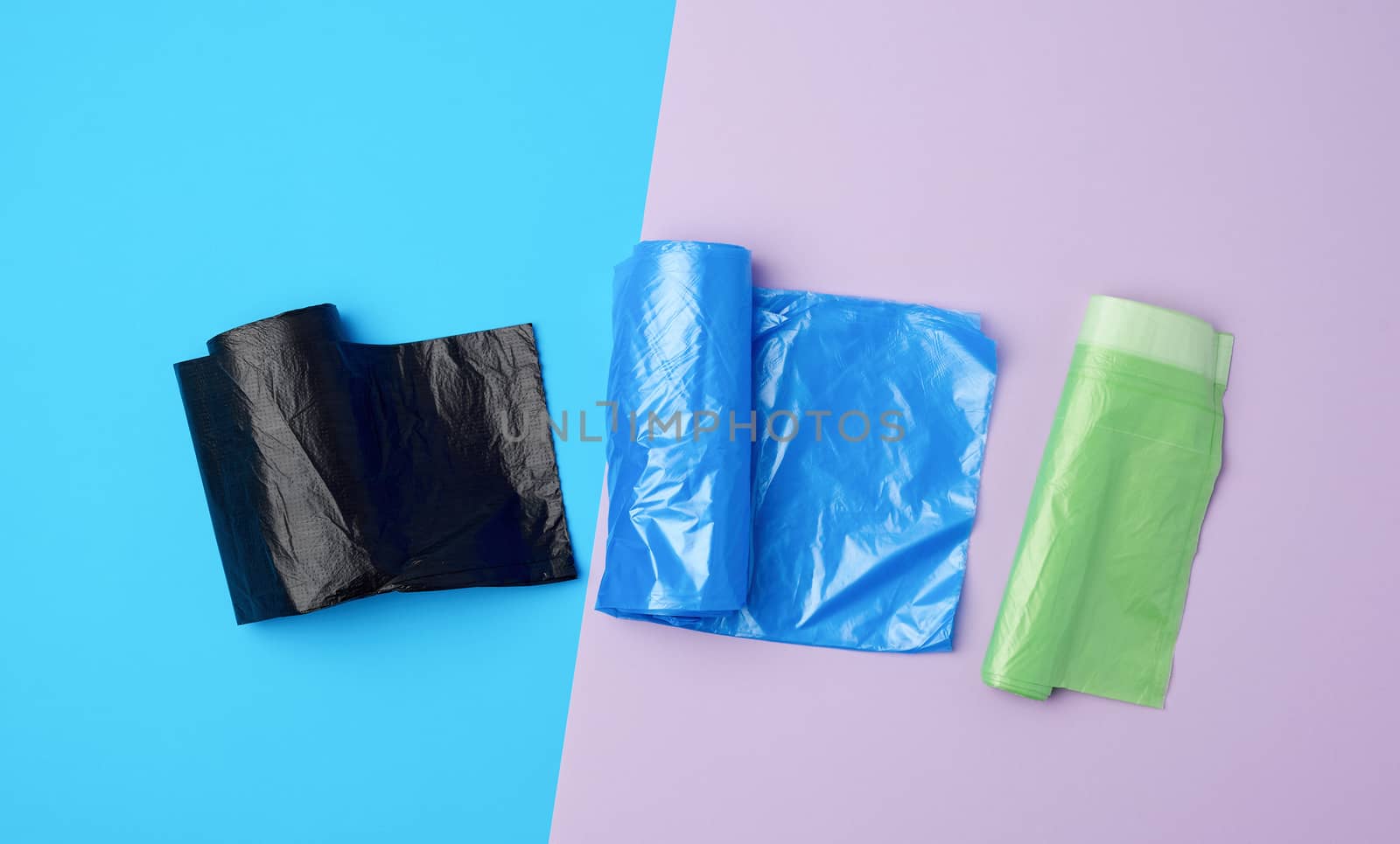 three rolled up rolls with plastic garbage bags on a blue background